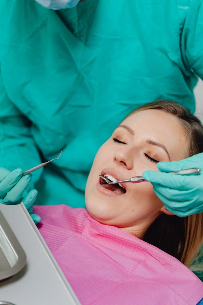 Woman receiving dental care during a routine checkup by a dentist in clinic.